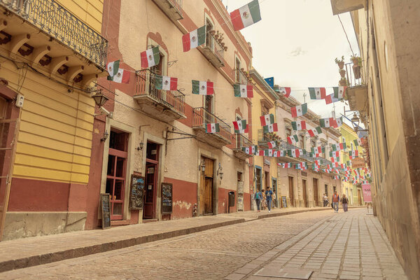 097 09 2025 Guanajuato Mexico Charming balconies with Mexican flags in the alleys of Guanajuato, Mexico, showcasing vibrant architecture, cultural identity, and festive heritage.