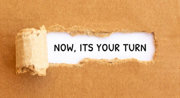 Text Now, Its Your Turn appearing behind torn brown paper,concept