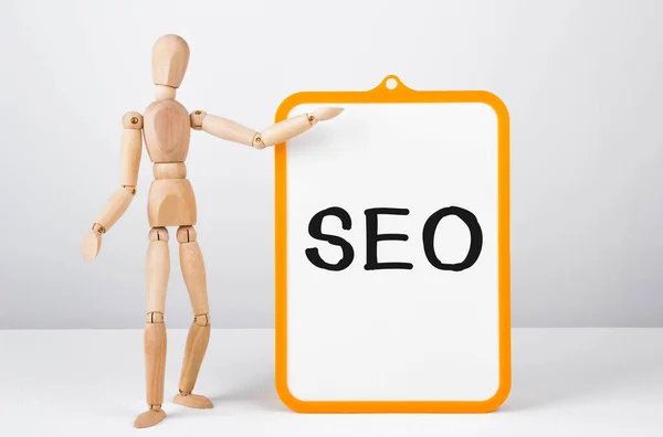 Wooden Man Shows Hand White Board Text Seo Concept — Stock Photo, Image