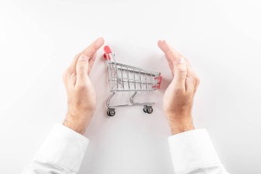 Güvenli online alışveriş konsepti. Beyaz arka planda elle korunan alışveriş arabası..