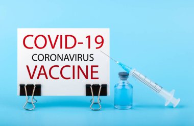 2019-ncov Covid-19 Corona Virüsü uyuşturucu aşısı konsepti. Mavi arkaplanda COVID-19 VACCINE yazılı kağıt