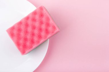 Pembe arka planda pembe bir sünger. Üst Manzara. Temizlik ve temizlik konsepti