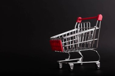 Kara Cuma konsepti. Boş alışveriş arabası siyah arkaplanda izole edildi.