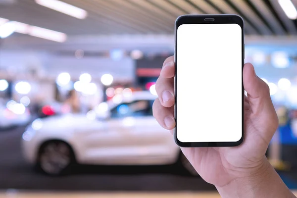 Mesajınız veya içeriğiniz için boş ekranlı akıllı telefonu bulanık araba gösterisi odası arka planına sahip olan el ele tutuşmanın kapatılması