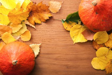 Sonbahar yaprakları ve ahşap arka plan üzerinde kabak