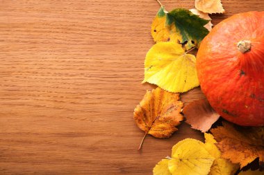 Sonbahar yaprakları ve ahşap arka plan üzerinde kabak