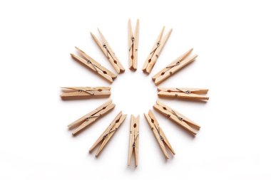 Beyaz arka plan üzerinde izole bir daire içinde düzenlenmiş ahşap clothespins grup.