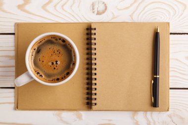 Business still life concept with office stuff on table. Business pocket planner and pen ready to note an appointment. Education, working or planning concept. Office desk with open paper notebook, pen