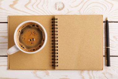 Business still life concept with office stuff on table. Business pocket planner and pen ready to note an appointment. Education, working or planning concept. Office desk with open paper notebook, pen