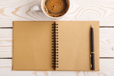 Business still life concept with office stuff on table. Business pocket planner and pen ready to note an appointment. Education, working or planning concept. Office desk with open paper notebook, pen