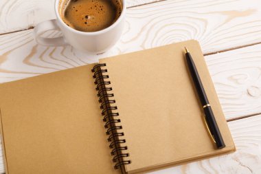 Business still life concept with office stuff on table. Business pocket planner and pen ready to note an appointment. Education, working or planning concept. Office desk with open paper notebook, pen