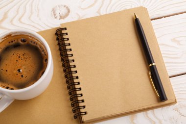 Business still life concept with office stuff on table. Business pocket planner and pen ready to note an appointment. Education, working or planning concept. Office desk with open paper notebook, pen