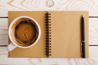 Business still life concept with office stuff on table. Business pocket planner and pen ready to note an appointment. Education, working or planning concept. Office desk with open paper notebook, pen
