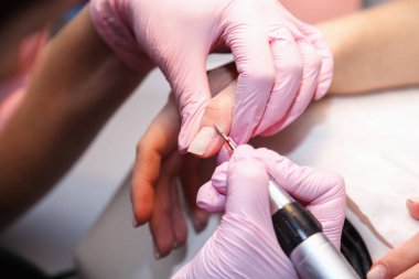 Manikür süreci yakın çekim ile tırnak parlatma makinesi. Donanım manikür modern güzellik salonda. Yordam oje uygulamadan önce çivi hazırlanması için.