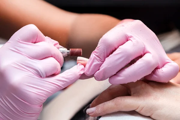Donanım closeup çekim bir güzellik salonu manikür. İşlem, manikür çivi bir freze kesici tarafından temizlik. Yordam oje uygulamadan önce çivi hazırlanması için.