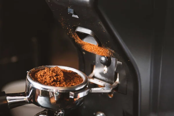 Barista kahve kahve makinesi kullanarak çekirdekleri taşlama, bir toz haline fasulye yapmak kahve değirmeni taze kavrulmuş taşlama.