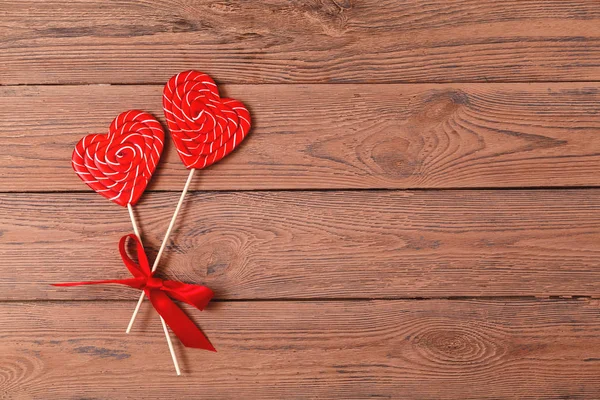 Two heart-shaped candy. Valentines day lollipops on a wooden background. Valentines Day background, wedding day. Candy. Love concept.