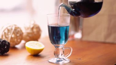 Mavi kelebek bezelye çaydan kafede masaya çiçek Clitoria. Çiçek mavi Tay çay şeffaf bir kaba dökülür. Çay kilo kaybı, sağlık, Detoks için