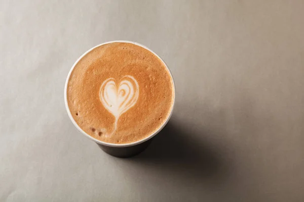 カフェラテやカプチーノ、灰色の背景に模様の心ラテアートの紙コップ。コーヒーに行きコーヒーを奪う ストック画像