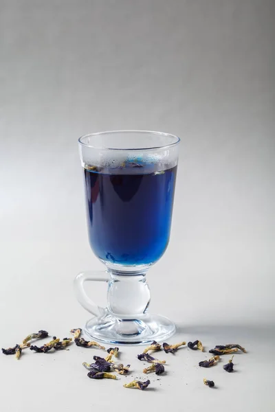 Vierta la leche en una taza de té de guisante azul Anchan sobre un fondo gris. Té tailandés azul y leche mezclada — Foto de Stock
