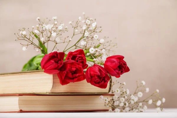 Nature morte vintage avec des tulipes rouges printanières et des livres sur fond beige. Fête des mères, concept de fête des femmes — Photo