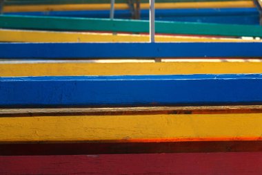 Renkli plaj bankları bir yığın halinde yığılmış, yakın çekim. Soyut arka plan, geometri