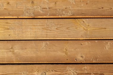 Ahşap arka plan. Kumda kaykaylar. Kumda yıpranmış ahşap kaldırım. Doğal malzemeler. Ahşap yüzey dokusu