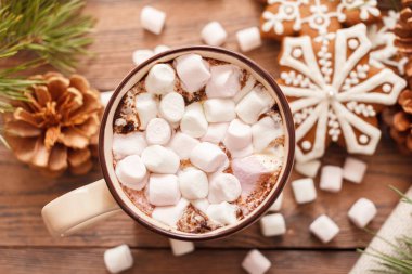 Bej rengi bir fincan geleneksel Noel sıcak çikolatası ya da şekerli kakao. Tahta arka planda Noel zencefilli ekmeği