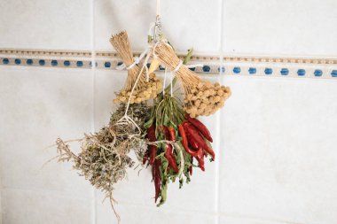 Kuru ot demetleri ve kırmızı biber duvarda asılı