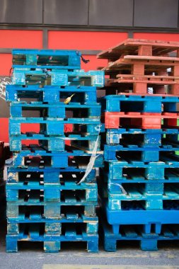 Sokakta mavi ve kırmızı ahşap paletler bir yığın