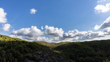 Doğal Garraf parkı, mavi gökyüzü ve bulutlu yeşil dağlar, Mas alba, Sitges, İspanya
