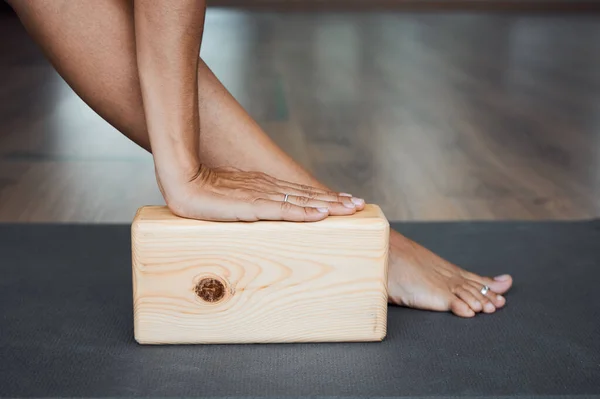Genişletilmiş üçgen pozu tuğla yakın çekim, utthita trikonasana pozu yoga iyengar 'da ahşap blok kullanılır