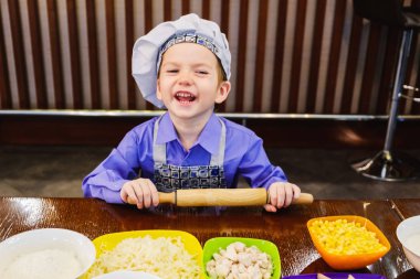 İtalyan pizza pişirme ana sınıf çocuk, küçük çocuk bir şef gibi giyindi
