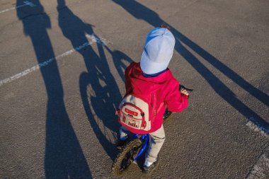 Etkin sarışın çocuk çocuk parkta bisiklet sürüş. Rüya ve sıcak yaz gününde eğleniyor yürümeye başlayan çocuk. Açık havada oyun çocuklar için. Denge Bisikleti kavramı.