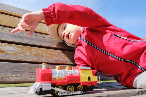 暖かい夏の日に屋外のおもちゃの汽車で遊んで子供男の子 小さな子供のためのおもちゃ — ストック写真