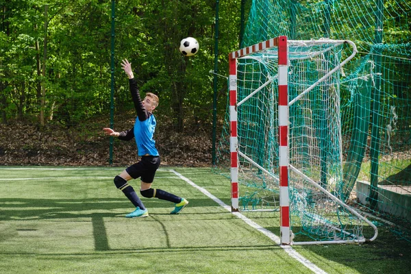 Kaleci topu yakalar. Stadyum kaleci spor zemin oyna, çim futbol kaleci adam, outdoorsc OMPETITION,