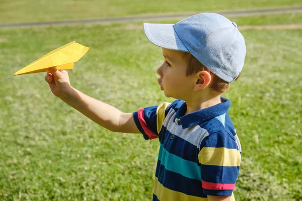 Bir sarı oyuncak uçak park adlı bir güneşli yaz gününde oynayan çocuk
