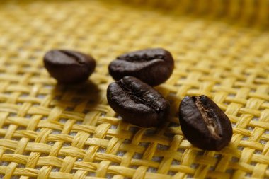 Sarı hasır sepetli taze kavrulmuş makro kahve çekirdekleri..