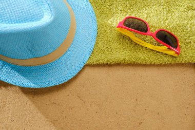 Kumlu plaja havlu çerçeve ve yaz aksesuarları ile en iyi görünümü. Arka plan kopya alanı ve görünür kum doku ve havlu ile