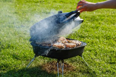 Smokehouse doğada yaz bahçesinde ızgara üzerinde duruyor. Balık evde aileniz için sigara.