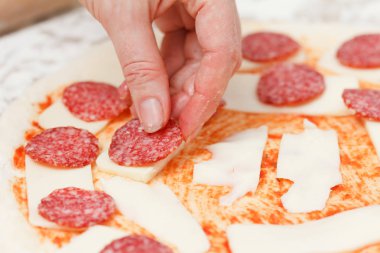 Salam mozzarella üzerinde bir ham pizza yakın çekim koyarak Cook