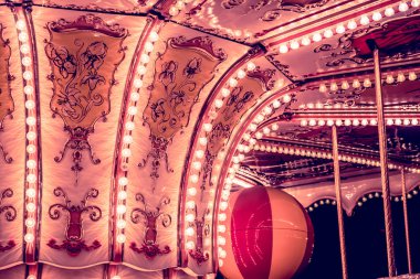 Çocuk Carousel, akşam ve gece aydınlatma bir eğlence parkında. gece eğlence parkı. Açık vintage renkli atlıkarınca içinde şehir. Vintage fotoğraf işleme