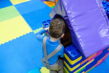 Mutlu gülen çocuk doğum günü partisi çocuk eğlence parkı ve kapalı oyun Merkezi'nde eğleniyor. Çocuk Bahçesi renkli oyuncaklar ile oynama. Küçük bir çocuk için aktivite oyuncakları