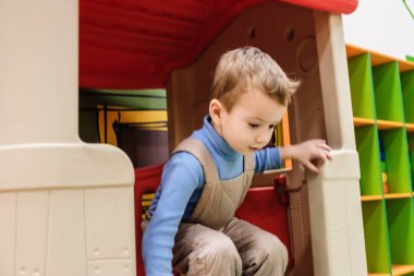 Mutlu gülen çocuk doğum günü partisi çocuk eğlence parkı ve kapalı oyun Merkezi'nde eğleniyor. Çocuk Bahçesi renkli oyuncaklar ile oynama. Küçük bir çocuk için aktivite oyuncakları