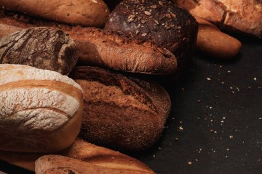 Masada taze kokulu ekmek. Siyah arka planda gıda kavramı.