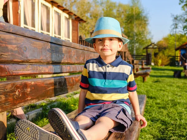 Усміхнена Дитина Сидить Лавці Парку Зеленим Лугом Фоні — стокове фото