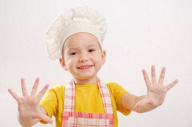 Çocukların ellerinin hamur yoğuruşuyla ilgili detaylar. Neşeli aşçı şapkalı çocuk burrito ya da pizza hazırlar.