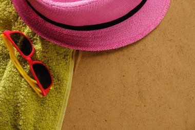 Kumlu plaja havlu çerçeve ve yaz aksesuarları ile en iyi görünümü. Arka plan kopya alanı ve görünür kum doku ve havlu ile