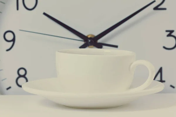 time for a coffee break during work with coffee cup and clock at ten o clock isolated on white