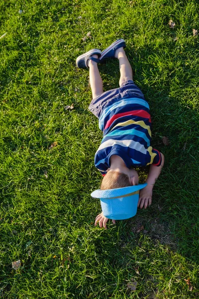 草の上に横たわるハンサムな少年 小さな夢は 帽子で草原にあります 都市の外の自然の子 気楽な娯楽 — ストック写真